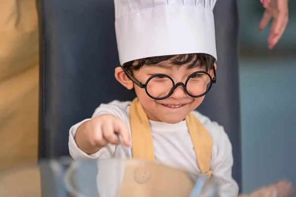 Retrato lindo pequeño asiático feliz chico interesado en cocinar con — Foto de Stock
