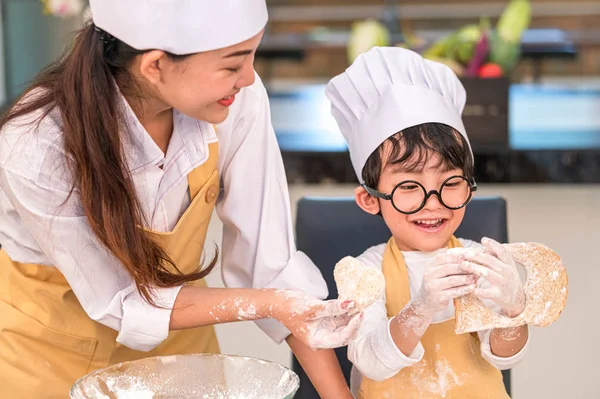 Hermosa mujer y lindo poco asiático chico con gafas, chef — Foto de Stock