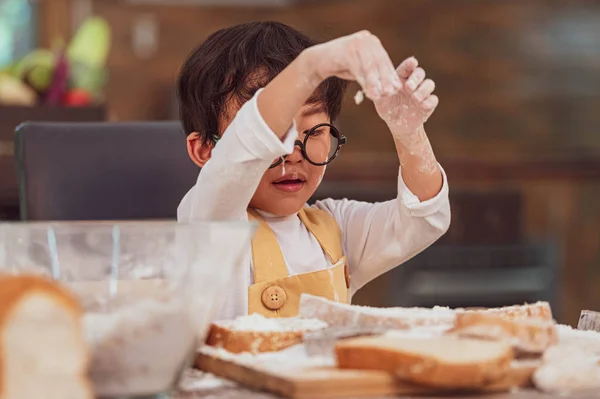 Retrato lindo pequeño asiático feliz chico interesado en cocinar con — Foto de Stock