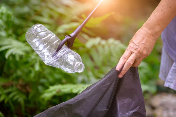 Primo piano di mano e raccoglitore di rifiuti raccogliendo bere plastica bo — Foto Stock