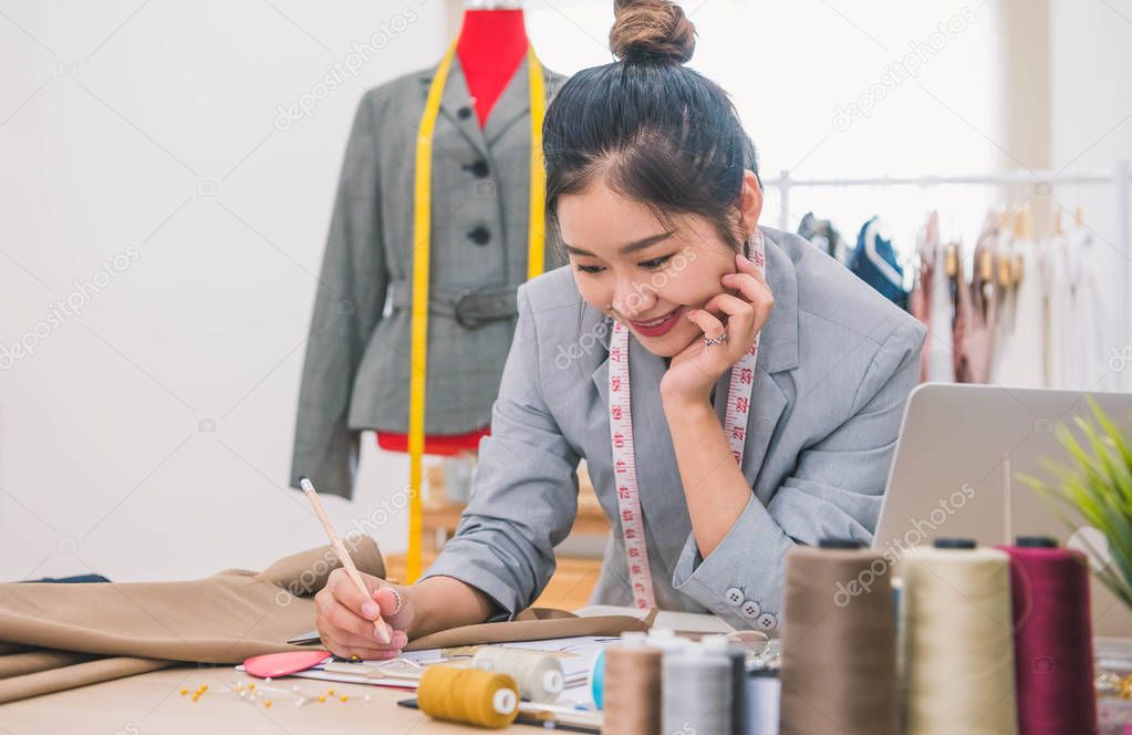 Attractive Asian female fashion designer  working in home office