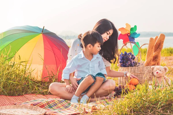 Beautiful Asian mother and son doing picnic and in Easter summer
