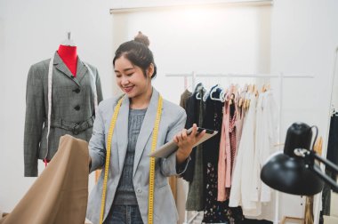 Tablet ile iş sahibi atölyesinde moda tasarımcısı stilist 