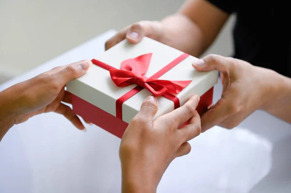 Closeup of hands giving gift box in Christmas day and new year f — Stock Photo, Image