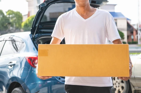 Nahaufnahme eines glücklichen asiatischen Mannes, der Pappschachteln an Kunden liefert — Stockfoto