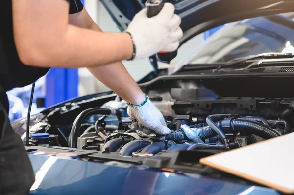 Asian male mechanic hold and shining flashlight to examine car e — Stock Photo, Image