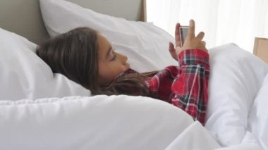 yatakta akıllı telefon kullanarak güzel asya kız görüntüleri