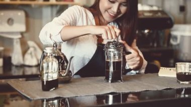 Kafede çalışan güzel Asyalı kadın barista Closeup