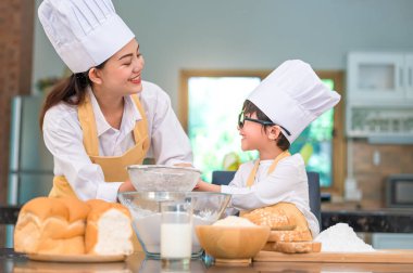 Sevimli küçük Asyalı çocuk ve güzel anne hamur un w eme