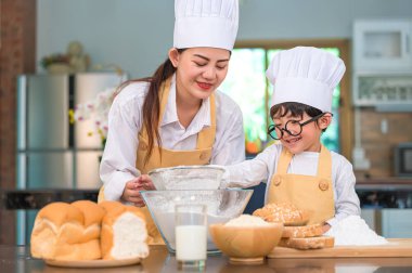 Sevimli küçük Asyalı çocuk ve güzel anne hamur un w eme