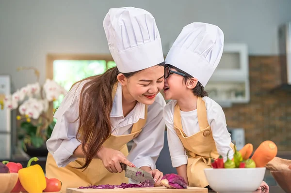 Feliz lindo niño con gafas besando hermosa asiática wo — Foto de Stock