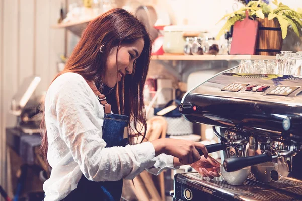 Professional female barista hand making cup of coffee with coffe