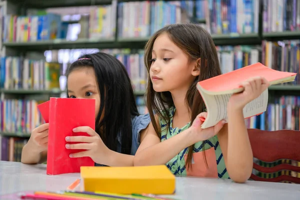 Dos niñas lindas amigos multiétnicos leyendo libros juntos —  Fotos de Stock