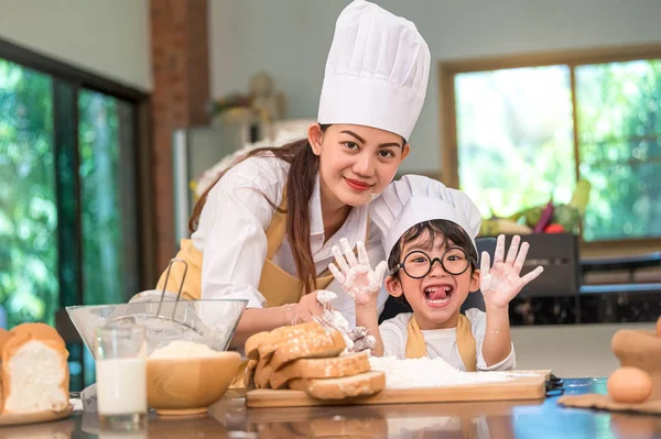 Hermosa mujer y lindo poco asiático chico con gafas, chef — Foto de Stock