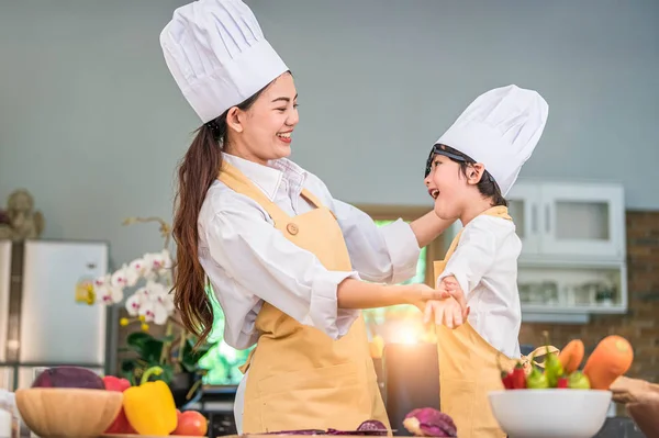 Feliz hermosa mujer asiática de vestir lindo traje de chef niño — Foto de Stock