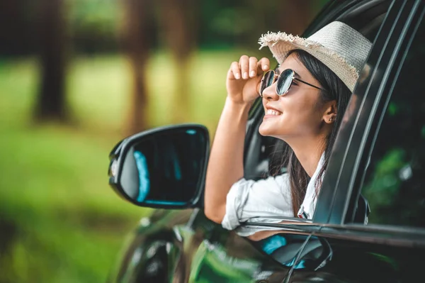 Glückliche Frau hält Hut vor offenem Fenster Auto mit grünen — Stockfoto