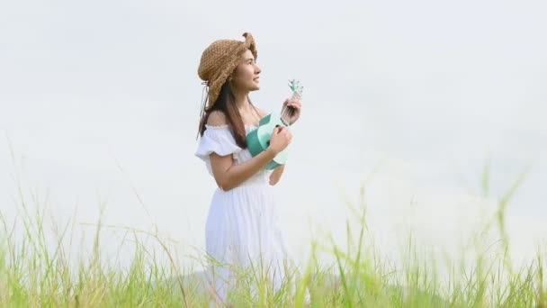 Aziatische Vrolijke Vrouw Witte Jurk Spelen Ukelele Gitaar Groene Weide — Stockvideo