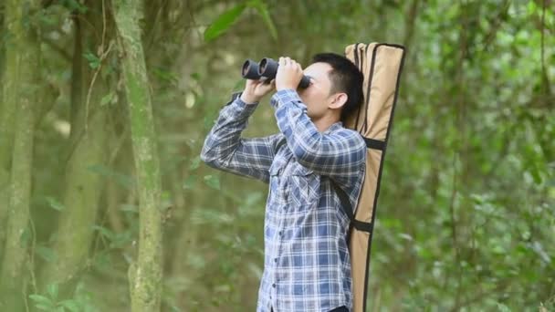 人用双筒望远镜在森林中寻找目的地 作为迷路的人或可预见的未来 人的生活方式和休闲活动的概念 自然和背包客旅行丛林背景 — 图库视频影像