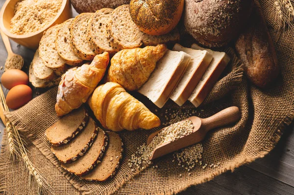 Diferentes tipos de pan con nutrición granos enteros en madera b — Foto de Stock