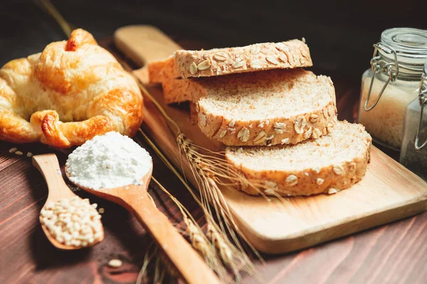 Diferentes tipos de pan con nutrición granos enteros en madera b — Foto de Stock