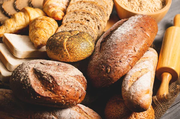 Diferentes tipos de pan con nutrición granos enteros en madera — Foto de Stock