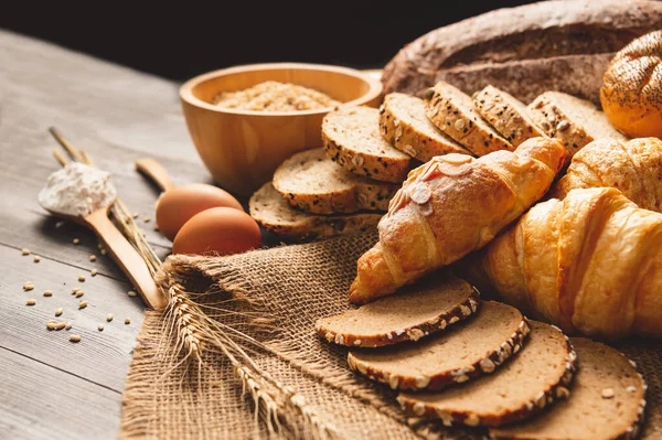 Berbagai jenis roti dengan nutrisi seluruh biji-bijian di kayu — Stok Foto