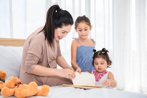 Azjatycka Matka Uczy Mieszane Wyścigi Córki Czytania Książek Ich Domu — Zdjęcie stockowe