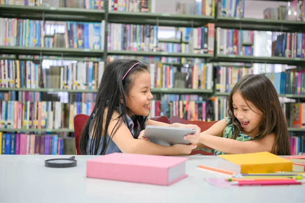 Dos Niñas Que Luchan Por Tableta Aula Mientras Leen Libros —  Fotos de Stock