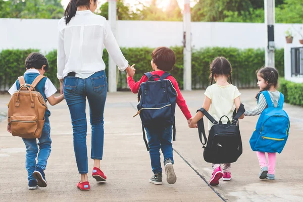 回到学校 学生妈妈一起上学 父母带着书包或书包一起送小男孩和小女孩去上第一学期的课 协作学习和移情日托 — 图库照片