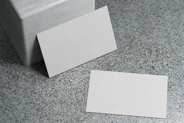 White business card paper mockup template with blank space cover for insert company logo or personal identity on marble floor background. Modern stationary concept. 3D illustration render