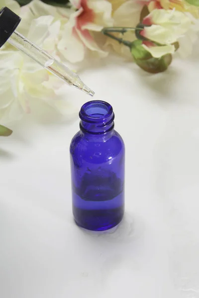 Blaue Flasche Und Tropfer Mit Schönen Blumen Hintergrund Für Ein — Stockfoto