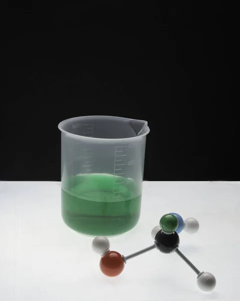 与其压实和液体在烧杯中的不同方面的分子 — 图库照片