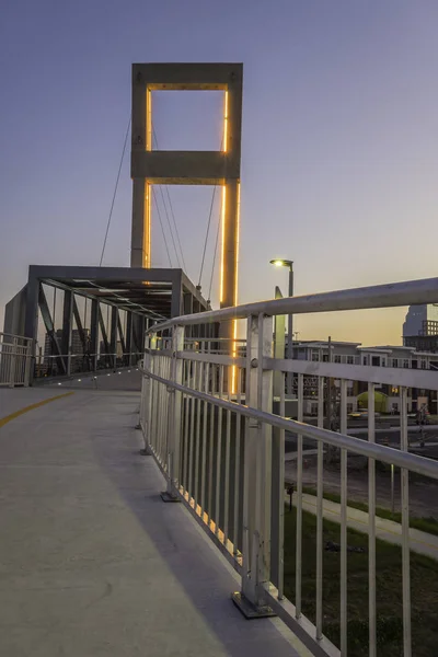 Pedestrian bridge spans over busy city street allowing for safe walking .