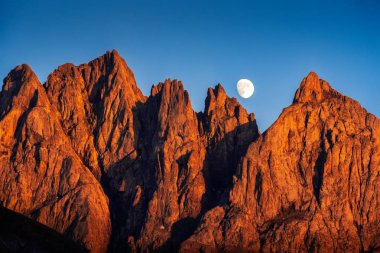 Manzaralı yükselen moon ile gün batımında güzel renkli dağ doruklarına