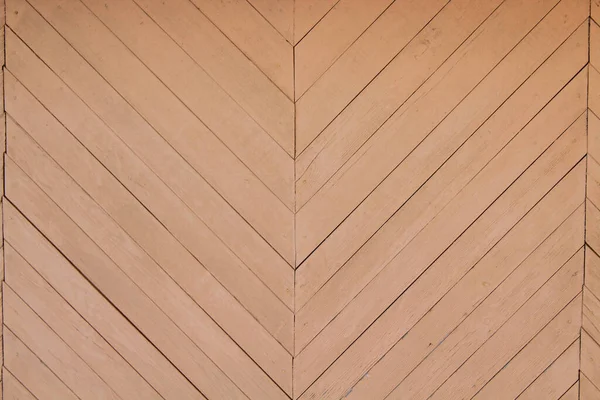 The wall of the house is made of thin boards in the form of a pattern. Close-up. Background. Texture.