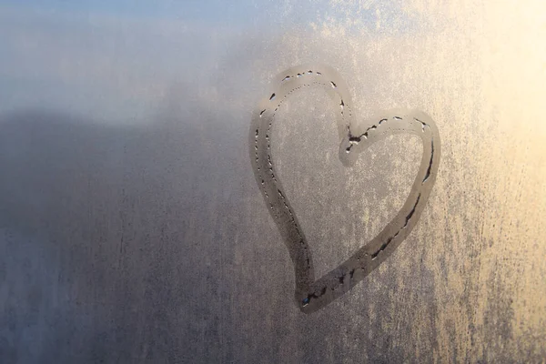 Finger drawn heart on glass. Close-up. Background. Texture.