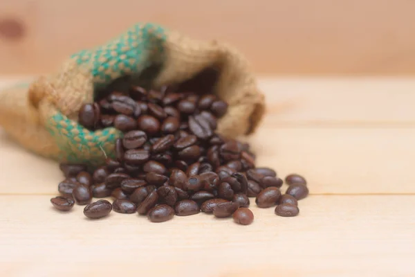 coffee beans in the bag on the brown wood background