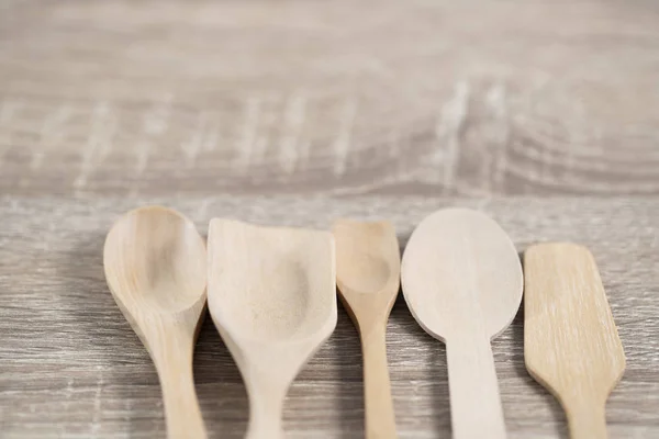 many wood spoons lay on brown wood table