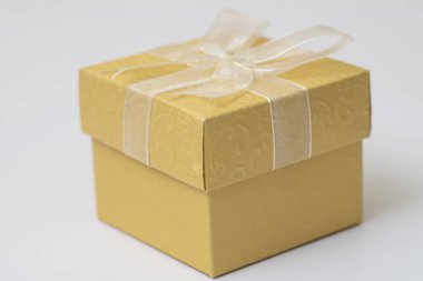 Altın hediye kutusu ile beyaz kurdele beyaz arka plan. üzerinde iyi duygu göndermek için özel bir izole