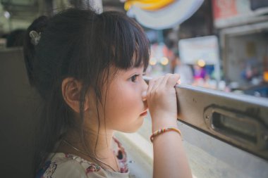 Pencereden bakan üzgün küçük kız