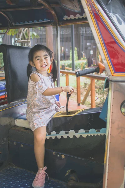 child learns to drive on tuk-tuk taxi