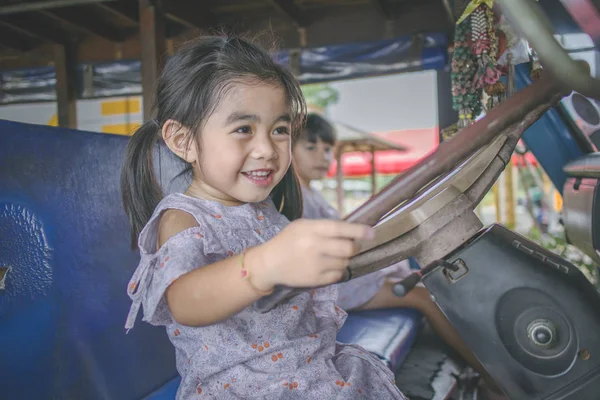 two child learns to drive the car