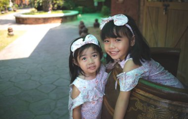 İki kız kardeş dışarıda eğleniyor.