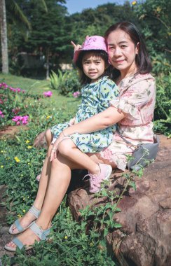 Anne ve kızı birlikte kameraya bakıyor.