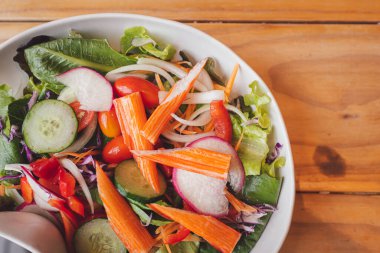 Kahverengi ahşap masaya saplanmış yengeç salatası.