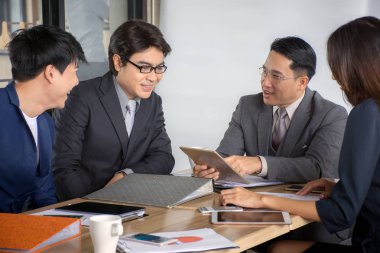 Grup Asyalı işadamı ve çalışma ve iş kadın ofiste masa raporları ile ekip içinde toplantı