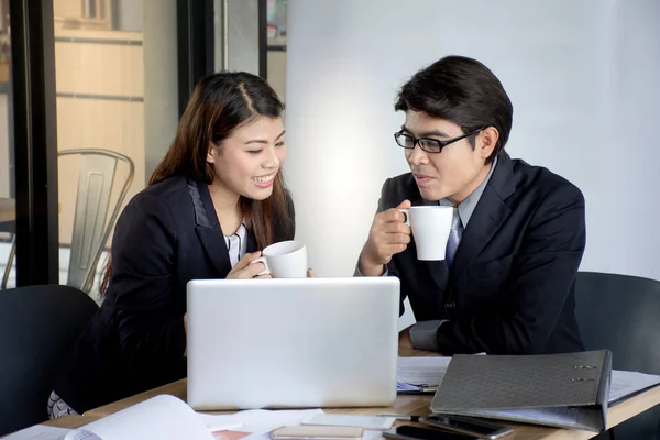 成功的商业团队或客户和顾客在会议 亚洲女商人讨论文件和膝上型电脑与男性同事在咖啡时间 免版税图库图片