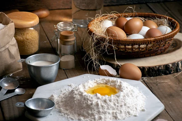 Eggs,dough and flour on wooden table with splat background for an object in a bakery