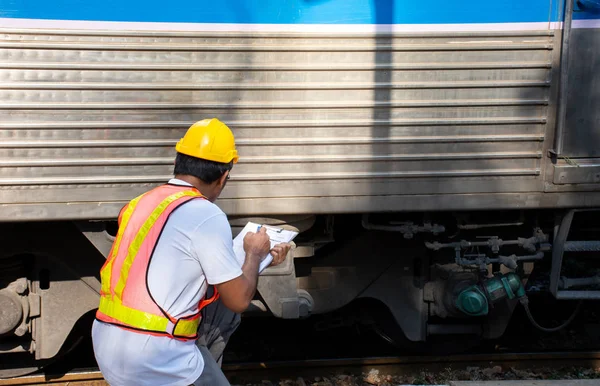 亚洲工程师戴安全帽 检查列车维修的图片 免版税图库图片