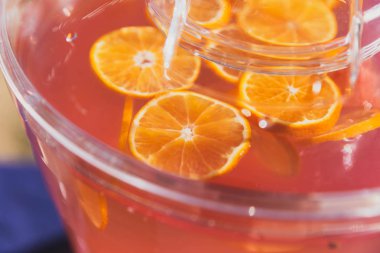 Büyük bir plastik sürahi içinde pembe bir içki portakal dilimleri tayin.